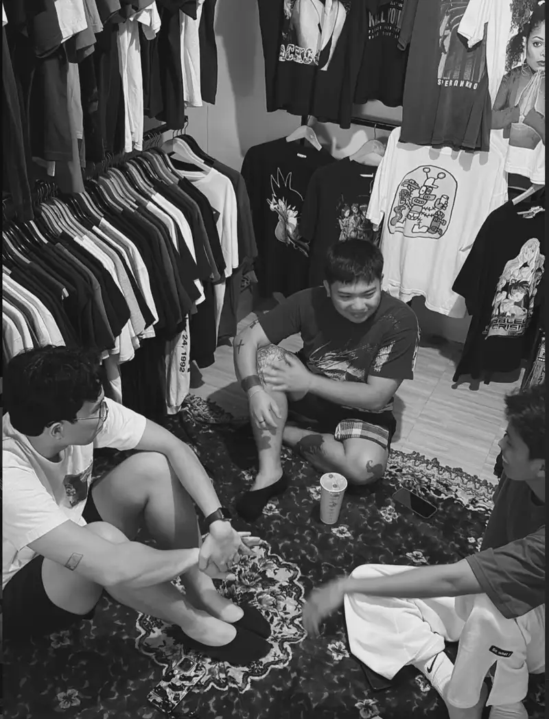 A curator sorting through a rack of vintage pieces in the backroom before a drop.